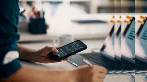 Mann mit Finanzdaten auf Smartphone FinTech