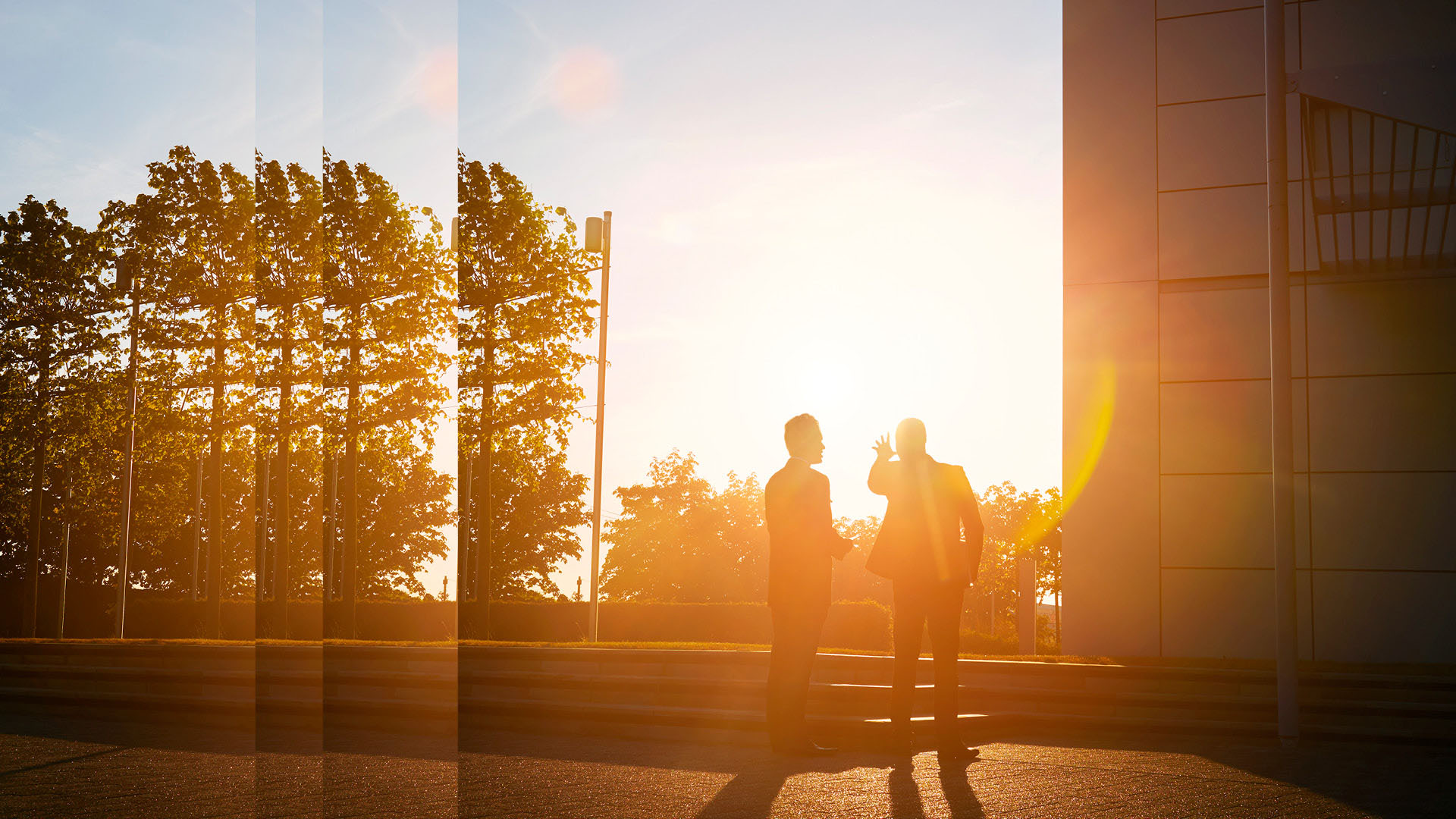 Zwei Geschäftsmänner im Gegenlicht eines Sonnenuntergangs Partner