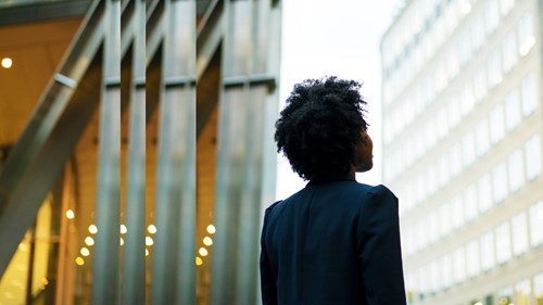 Frau schaut nach oben auf Gebäude
