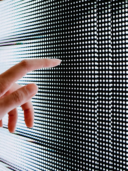 Hand, die ein LED Display berührt Digital Business