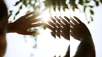 Person streckt Hände gegen Sonnenlicht Environmental, Social and Governance