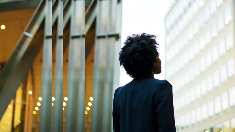 Frau schaut nach oben auf Gebäude