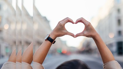 Hands forming heart symbol in city diversity