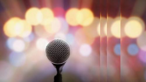 Microphone in front of lighted background stage awards